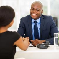 Man sitting and shaking a woman's hand