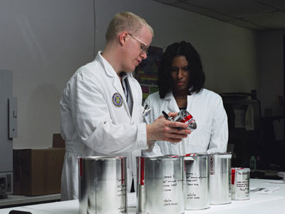 Two ATF forensic chemists reviewing evidence canisters
