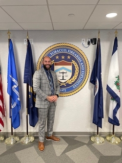 Justin standing in front of the ATF seal