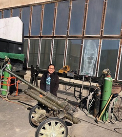 Katrina standing next to old artillery